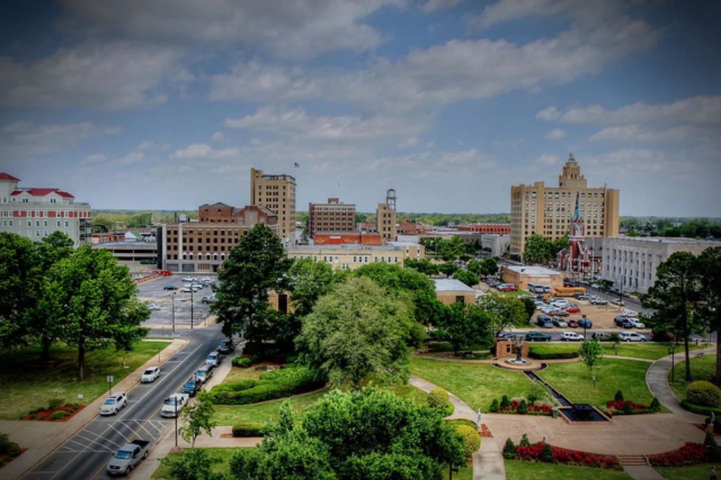 Chauffeur opening door for client using Louisiana, LA Car Service luxury black car in downtown Louisiana setting