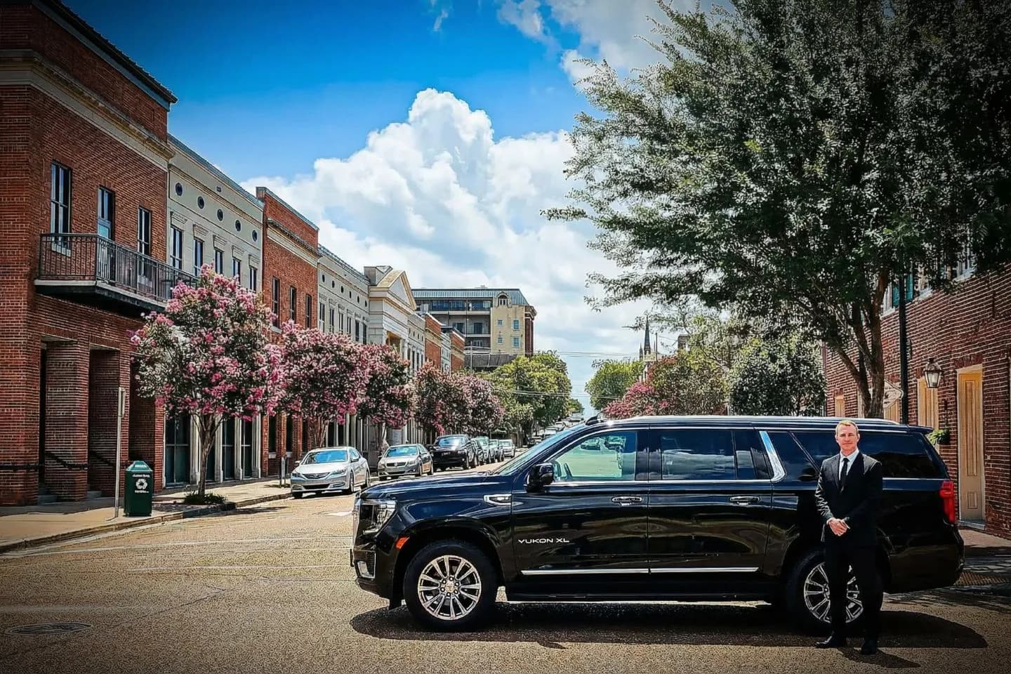 Clean black SUV used for Mississippi, MS Car Service with chauffeur standing beside vehicle