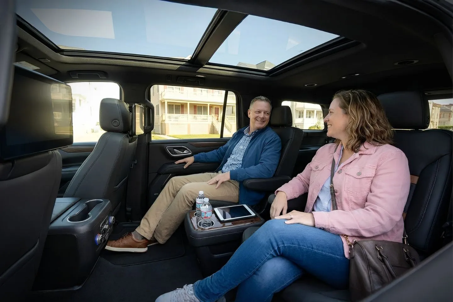 Elegant black car from Cape May NJ car service parked near coastal resort with uniformed driver