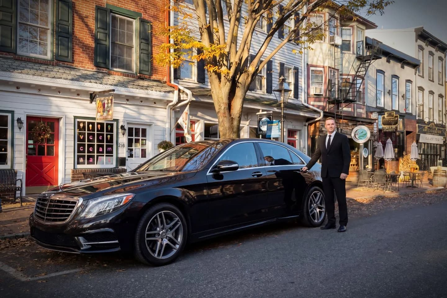 Minnesota, MN Chauffeur Service chauffeur opening door for client beside premium luxury vehicle in city setting