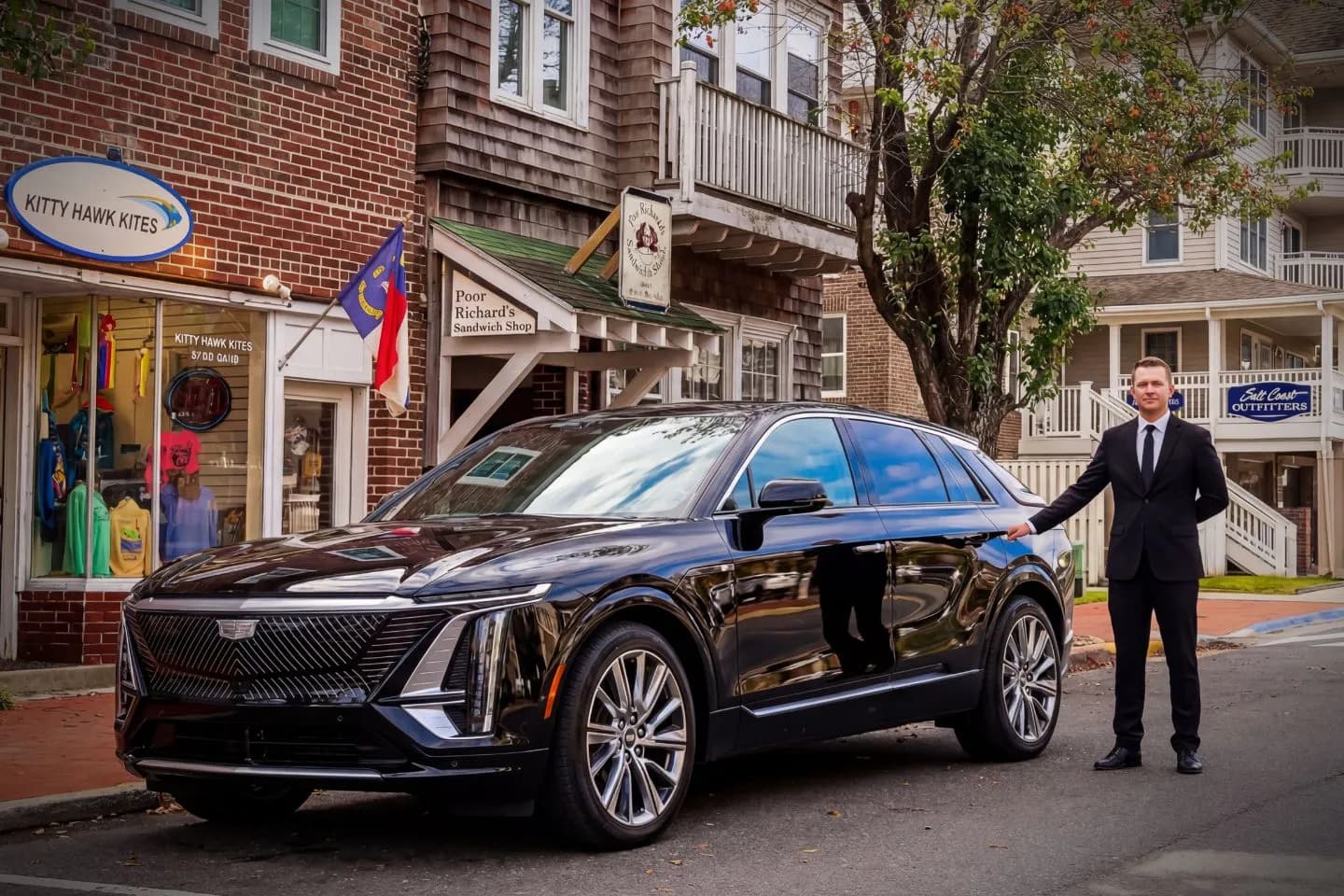 Luxury sedan with driver offering North Carolina, NC Chauffeur Service outside a modern airport terminal