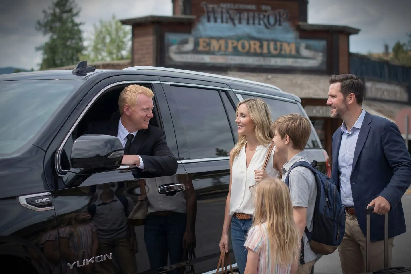 Black SUV from Washington, WA Chauffeur Service ready for corporate travel with suited driver standing beside vehicle
