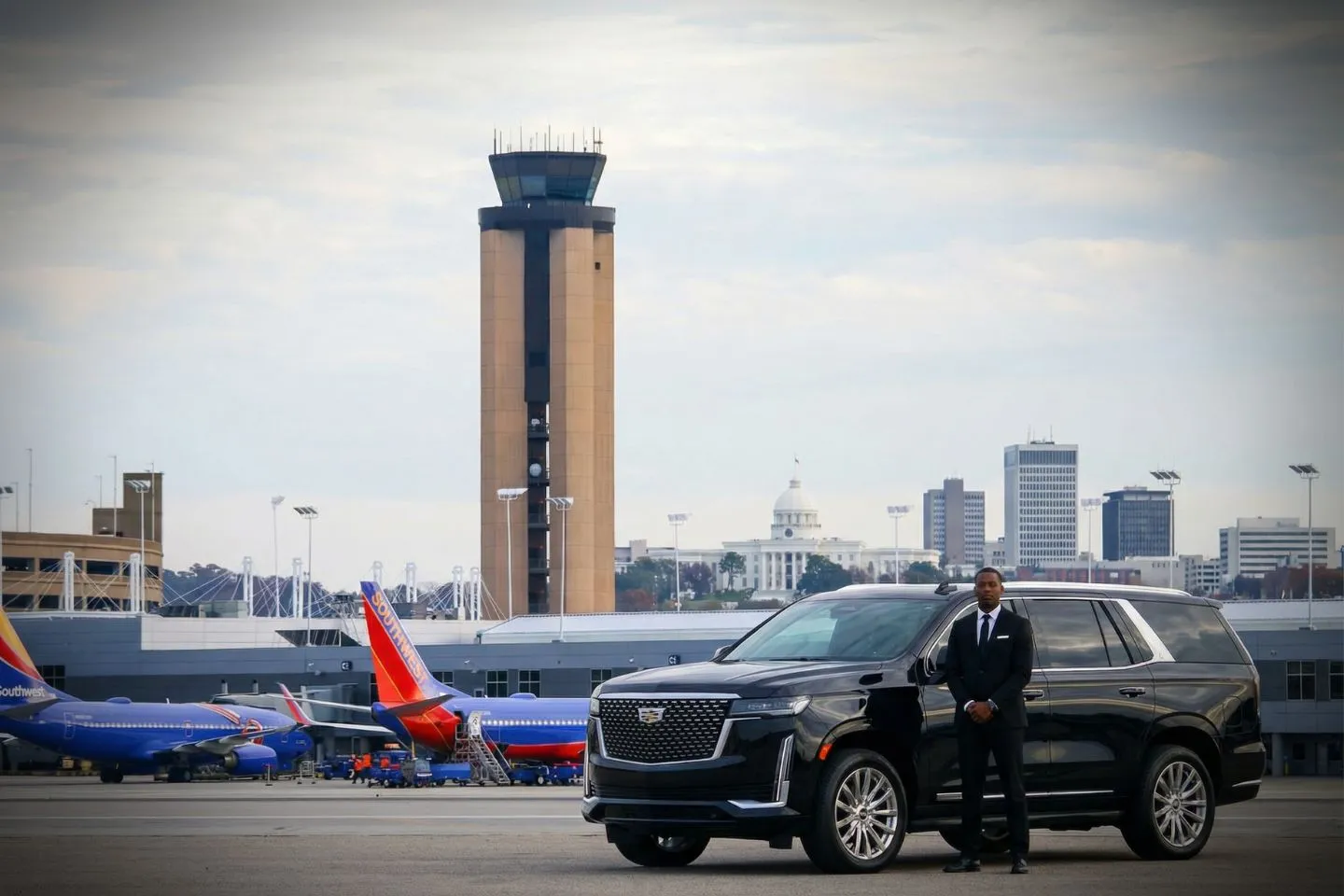 Professional chauffeur opening door for client using Alabama car service vehicle