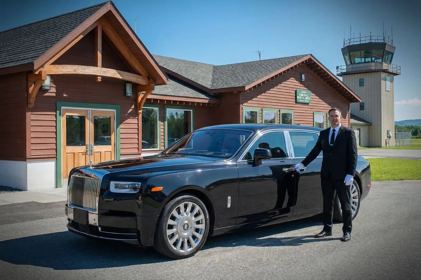 SLK Car Service premium airport transfer vehicle driving near Brooklyn Bridge with New York skyline view