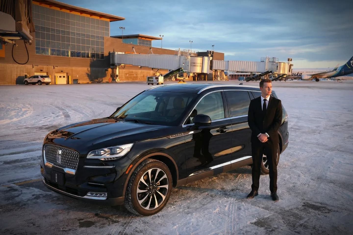 Black luxury sedan parked at Fairbanks International Airport terminal in Alaska