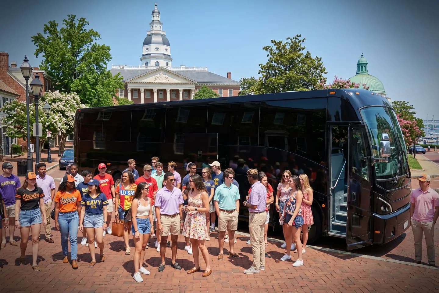 Uniformed chauffeur standing beside an open charter bus door in Maryland