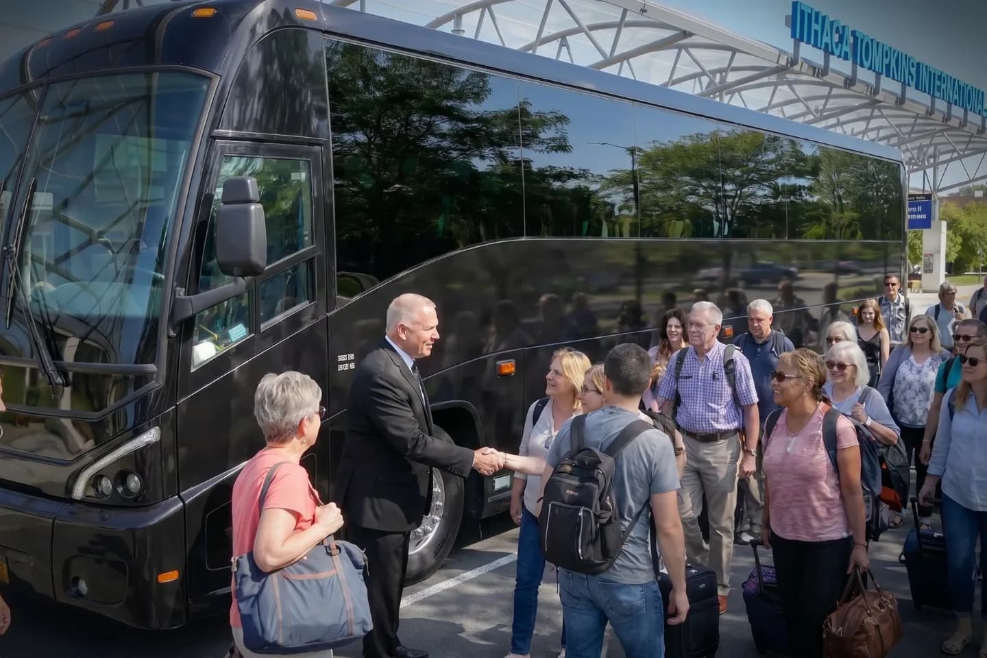 Luggage being loaded into a charter bus at Ithaca airport arrivals