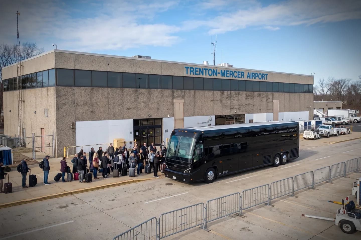 Small group loading bags onto a coach outside TTN airport in Ewing, New Jersey