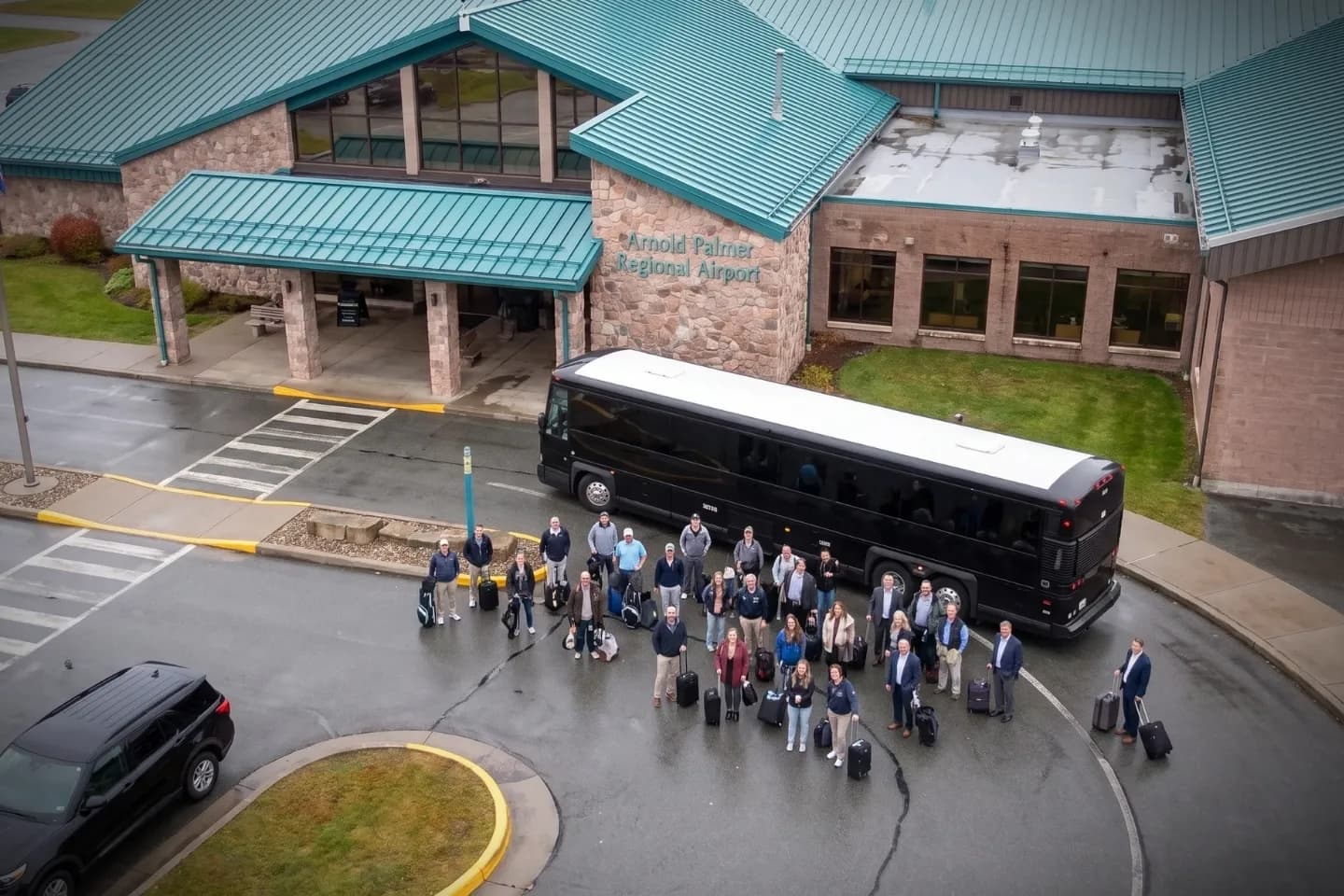 Passengers boarding a charter bus rental outside Arnold Palmer Regional Airport