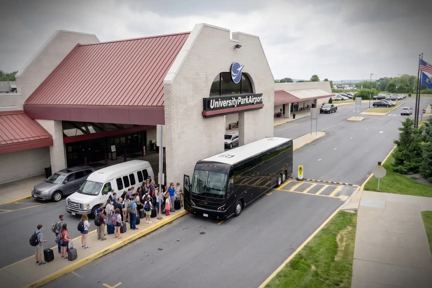 Travelers boarding a motor coach outside University Park Airport near State College