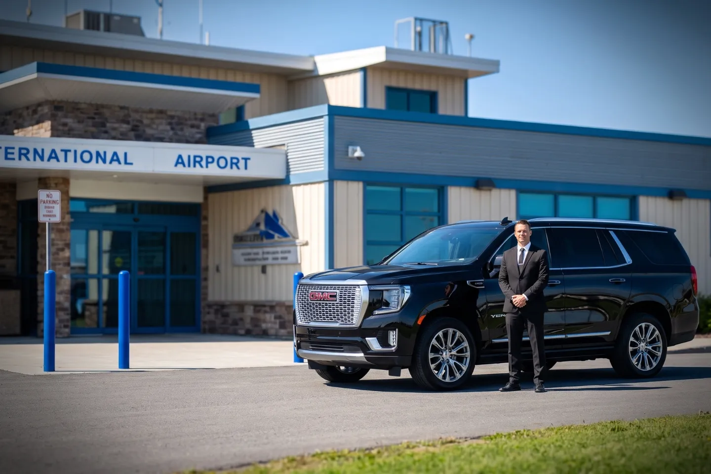 Black luxury sedan waiting at Watertown International Airport pickup curb