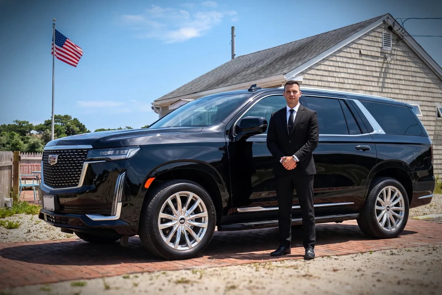 Chauffeured black sedan parked outside the Montauk Airport terminal building
