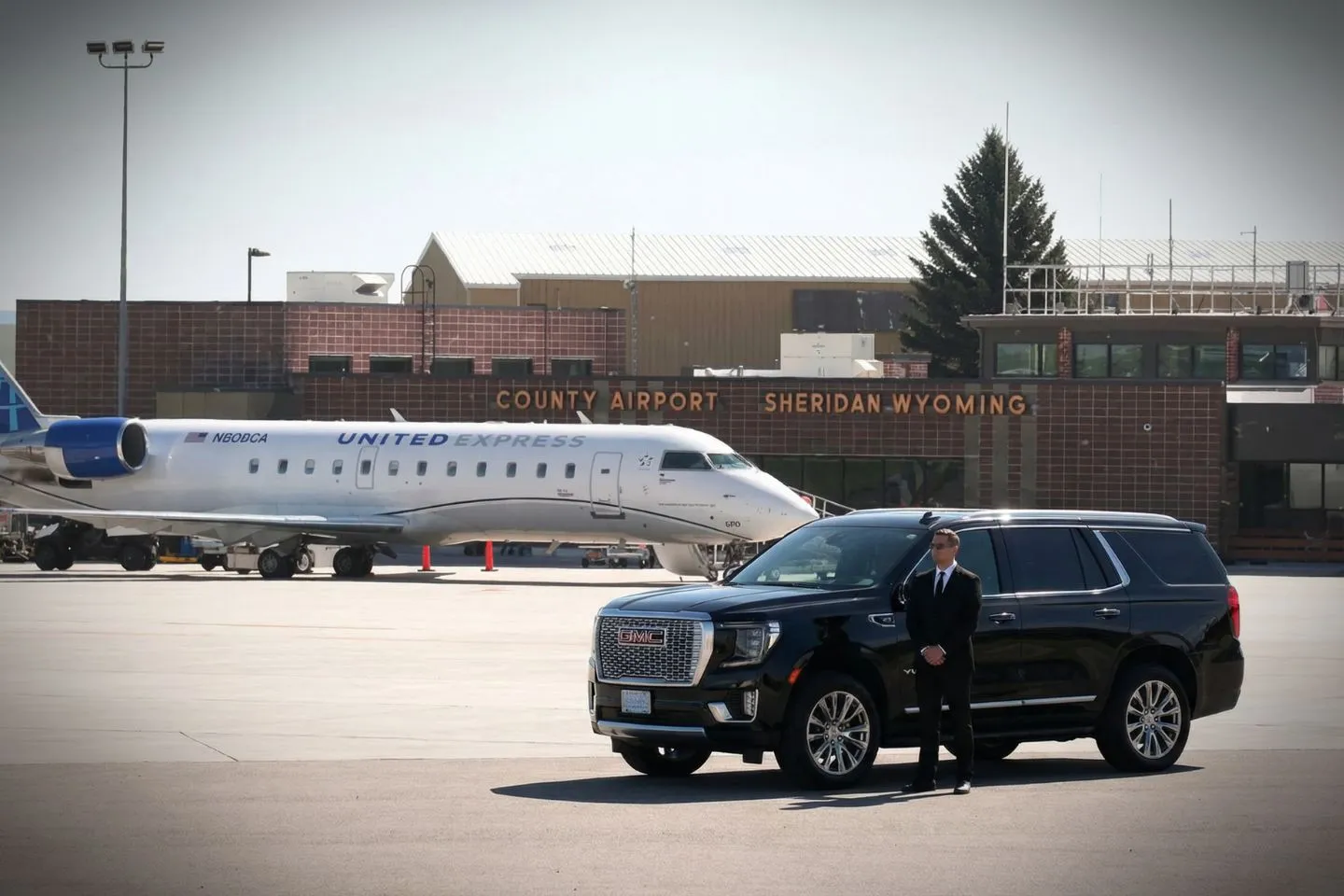Airport Car Service in Wyoming, WY Wyoming WY car service airport transfer with chauffeur assisting passenger with luggage