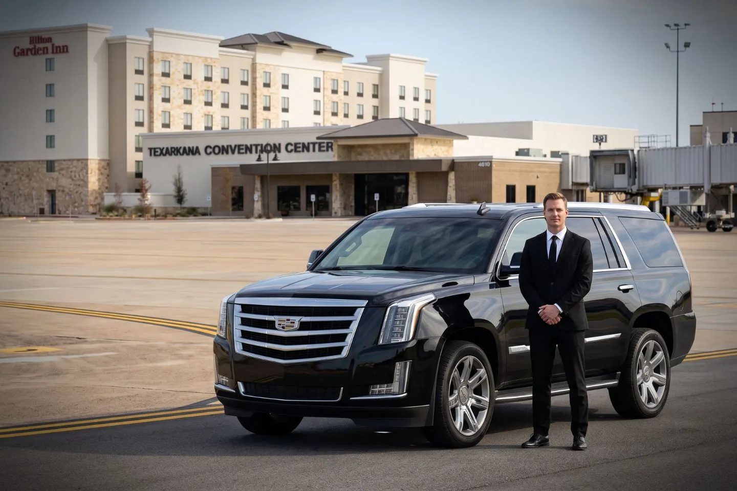 Texarkana Regional (TXK) Airport Car Service Black luxury sedan parked at Texarkana Regional Airport terminal curbside in Texas