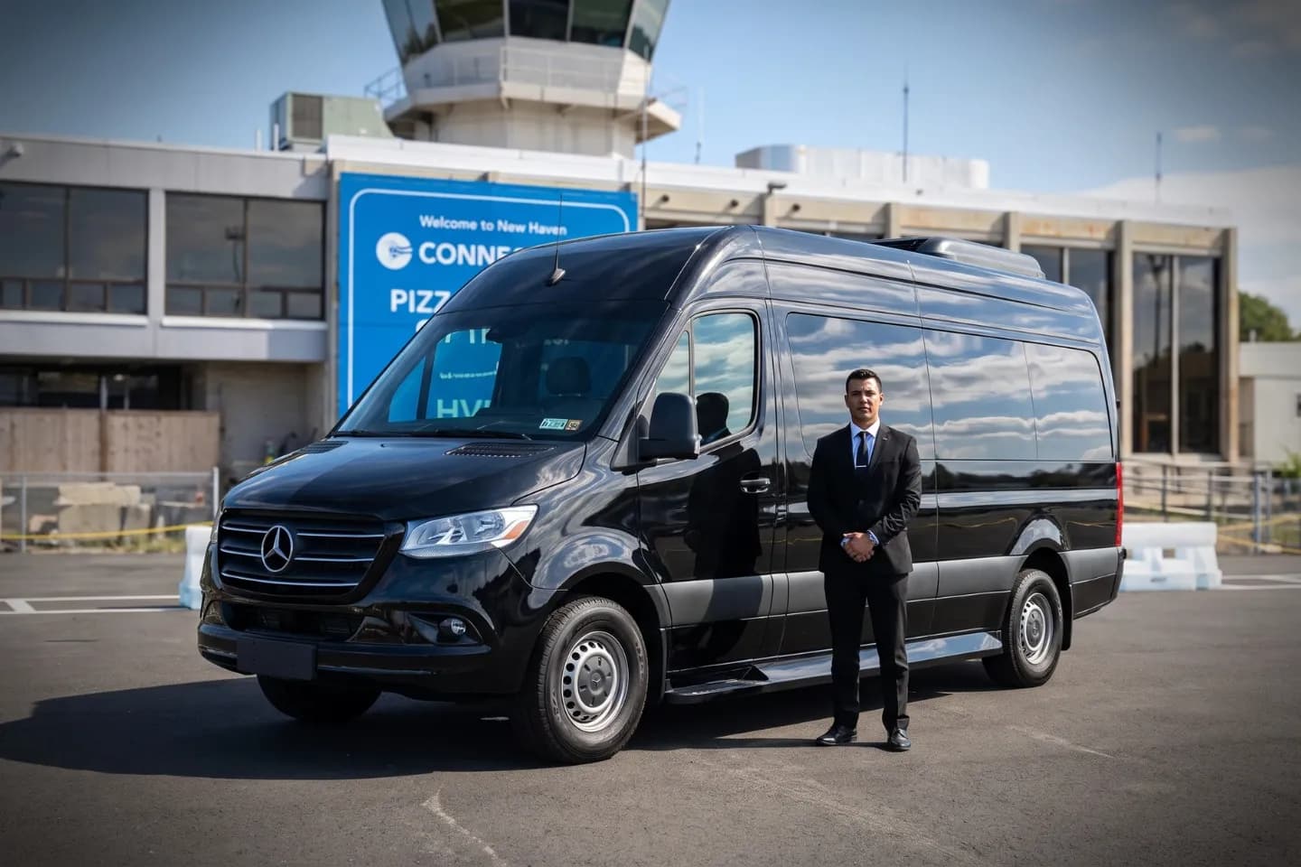 Tweed New Haven (HVN) Airport Sprinter Van Rental Black sedan parked near the Tweed New Haven Airport terminal for a scheduled pickup