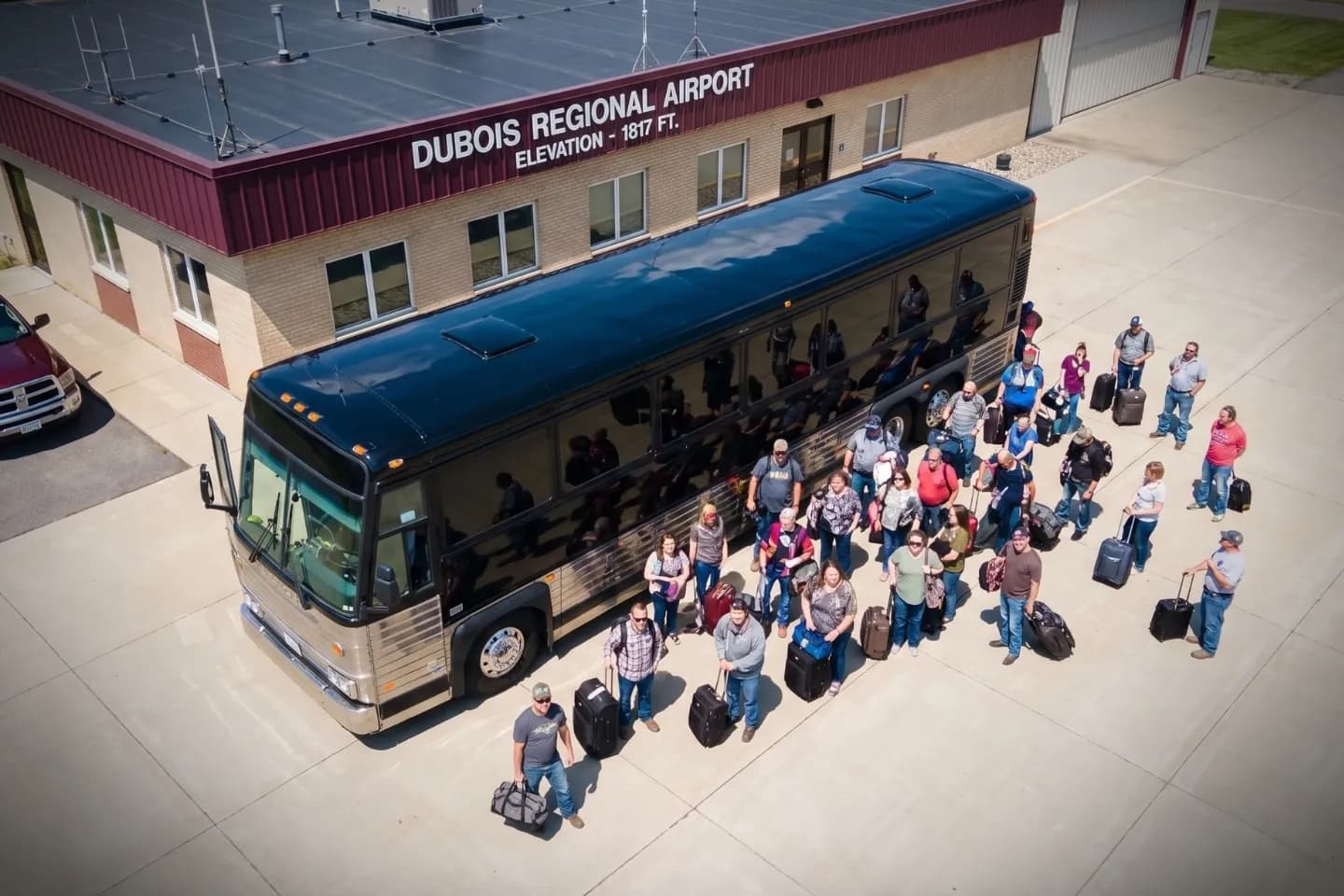 DuBois Regional (DUJ) Airport Charter Bus Rental Service Group boarding a motor coach outside DuBois Regional Airport in Pennsylvania