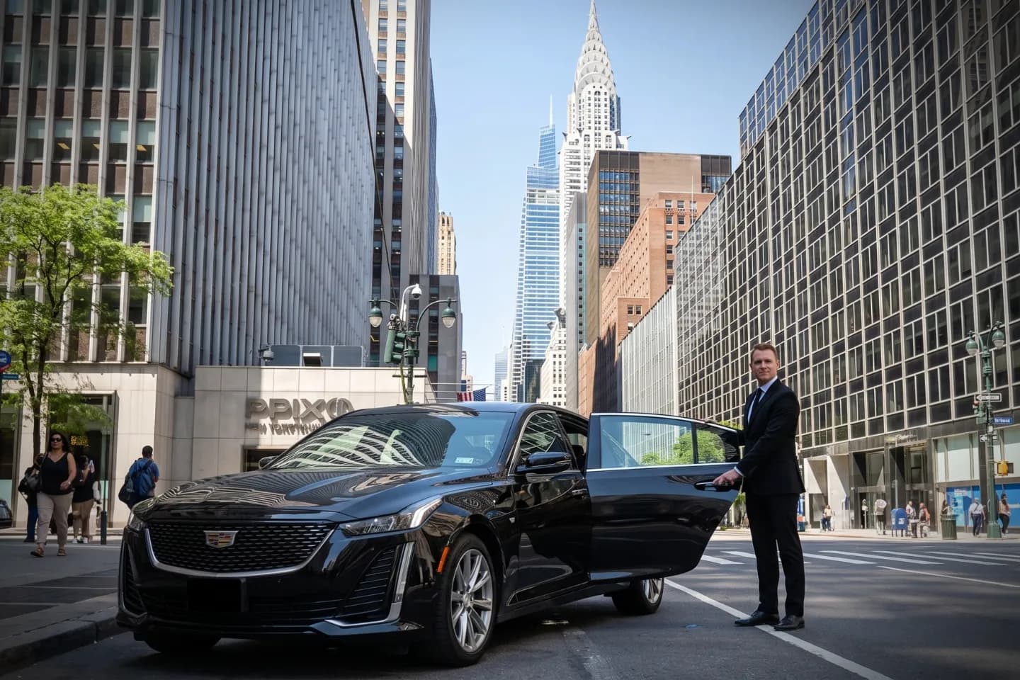Car Service in Midtown, Manhattan, NY Black luxury sedan waiting curbside on a busy Midtown Manhattan avenue