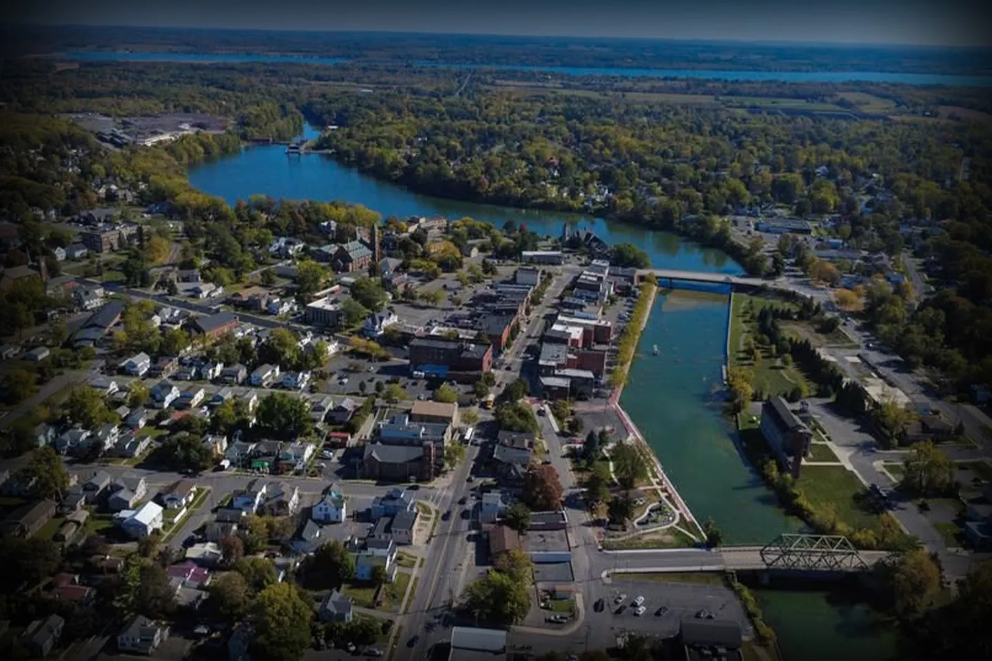 Luxury sedan from Seneca, NY Chauffeur Service parked outside upscale hotel with professional driver assisting passenger