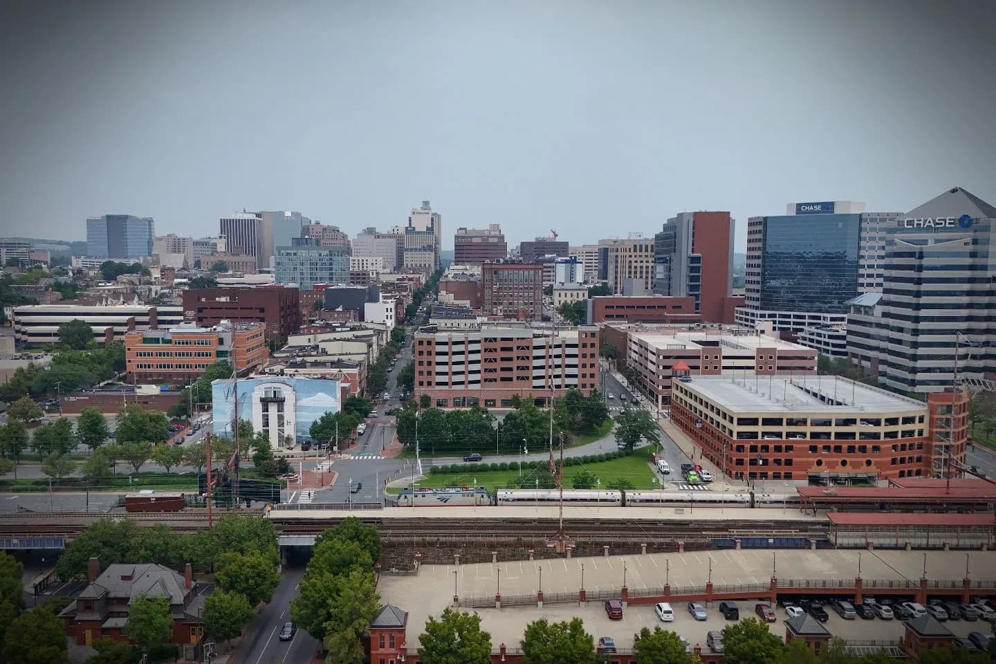 Chauffeur opening door for passenger using Delaware DE car service in downtown business district